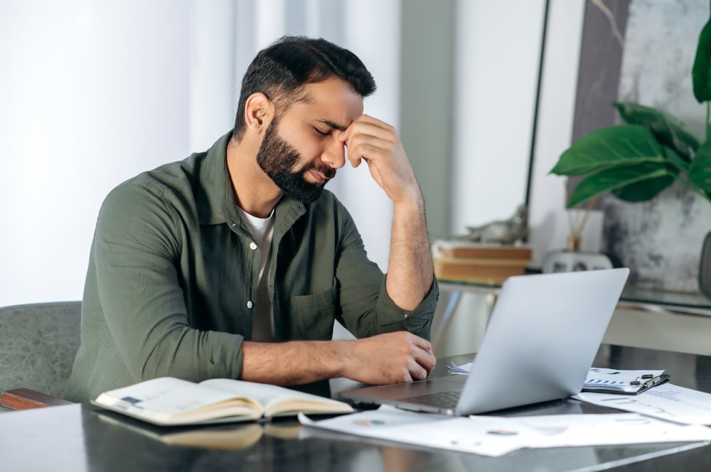Tired exhausted man sitting at his desk