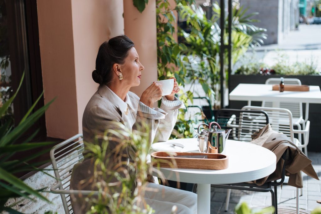 Bioidentical vs conventional HRT: woman relaxing at an outdoor cafe