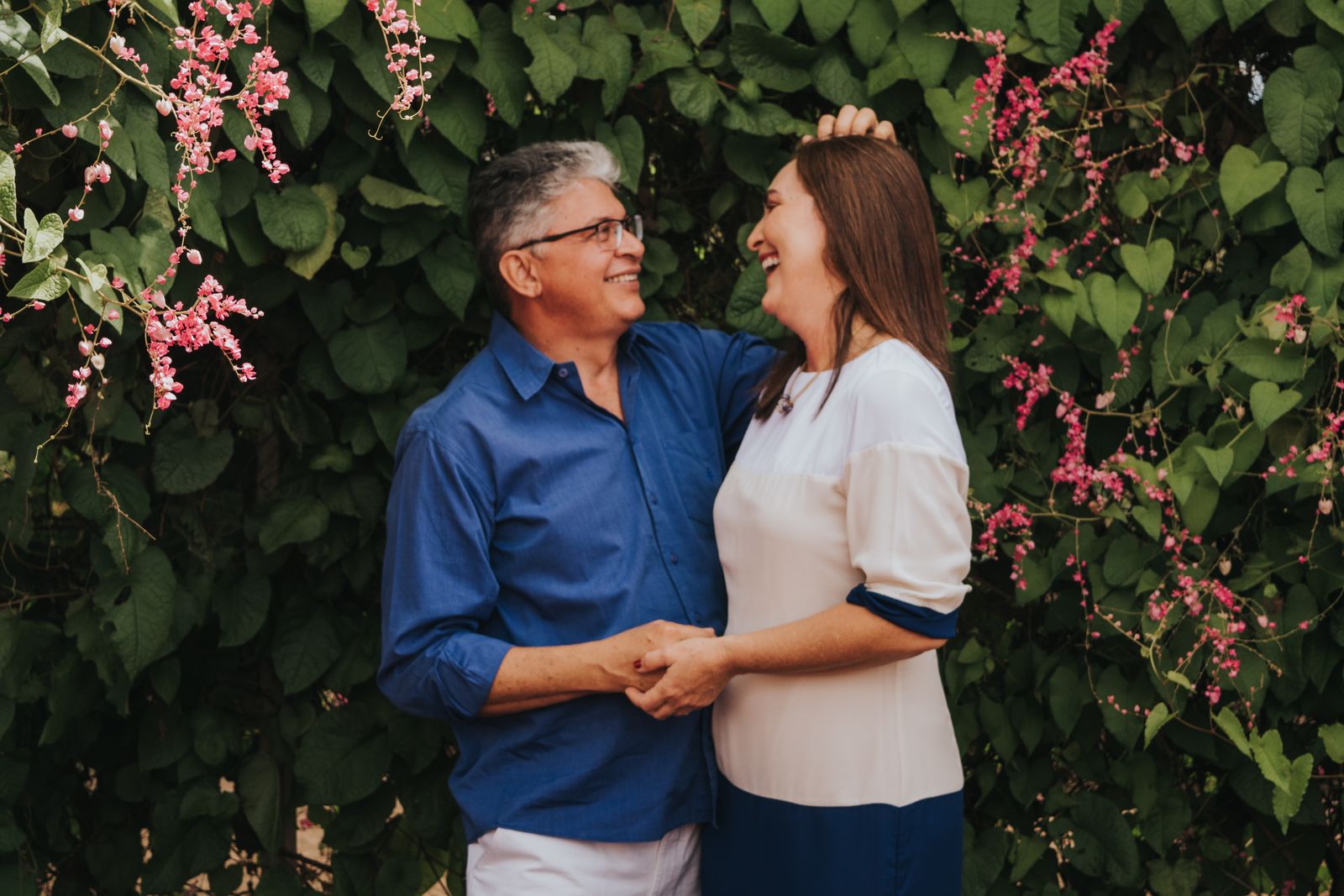 Functional medicine clinic in Skokie area: couple in their 50s laughing together outdoors among flowering greenery