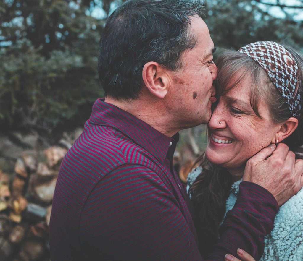 Functional medicine in Oak Park: couple in their 50s sharing an affectionate moment outside their home