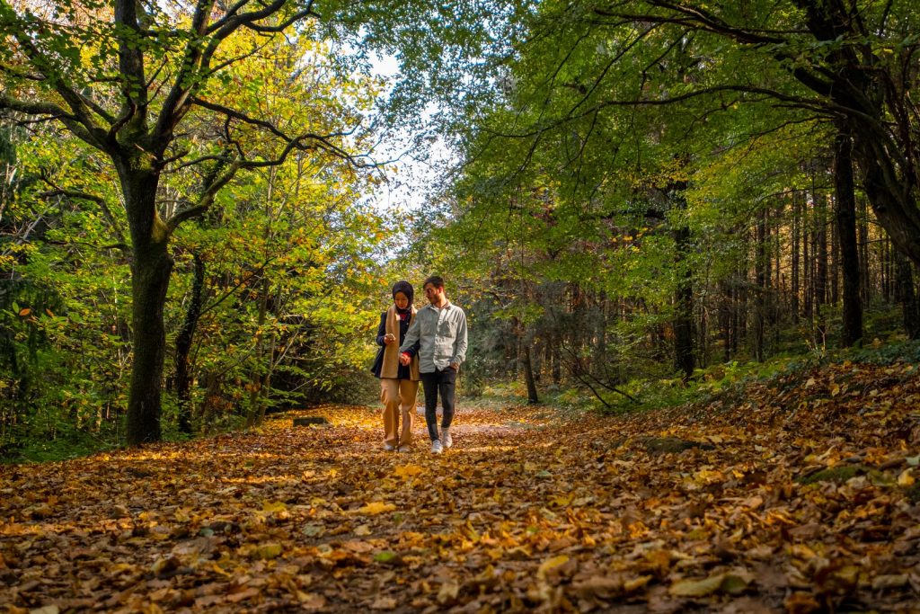 HRT Barrington: couple walking together on a leaf-covered wooded trail in autumn