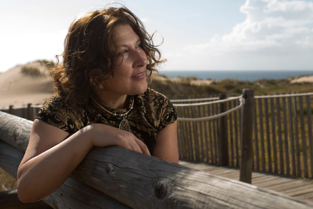 HRT Wilmette: confident woman in her 40s relaxing on a lakefront boardwalk by the dunes