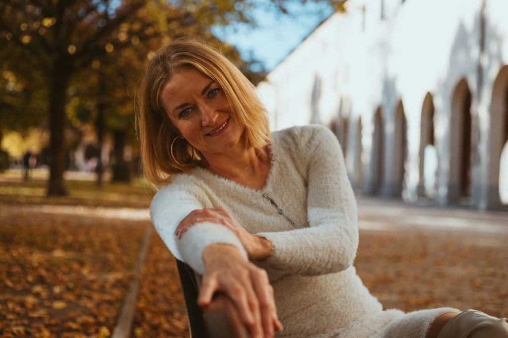 Menopause care: smiling woman relaxing in an autumn park