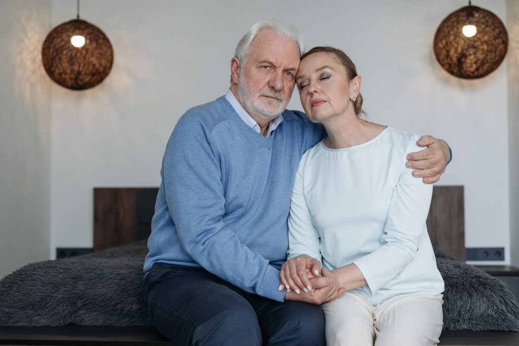 Quad mix dosage: grey-haired man in a blue sweater sitting close with his partner at home