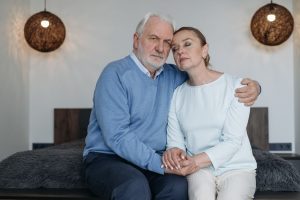 Quad mix dosage: grey-haired man in a blue sweater sitting close with his partner at home