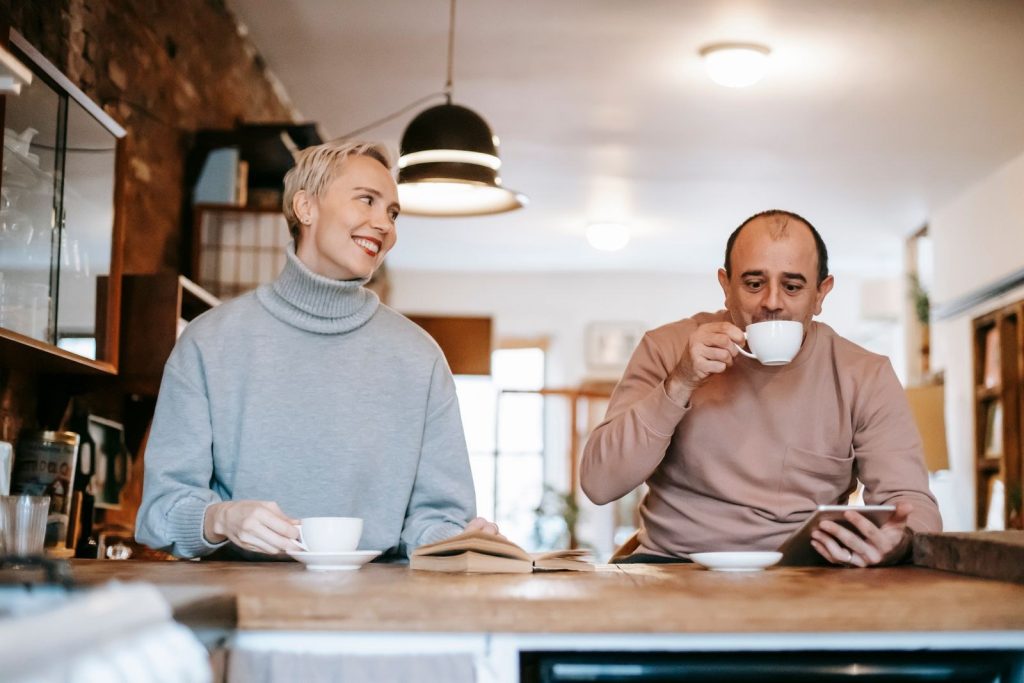 Couple sipping coffee together at a café counter