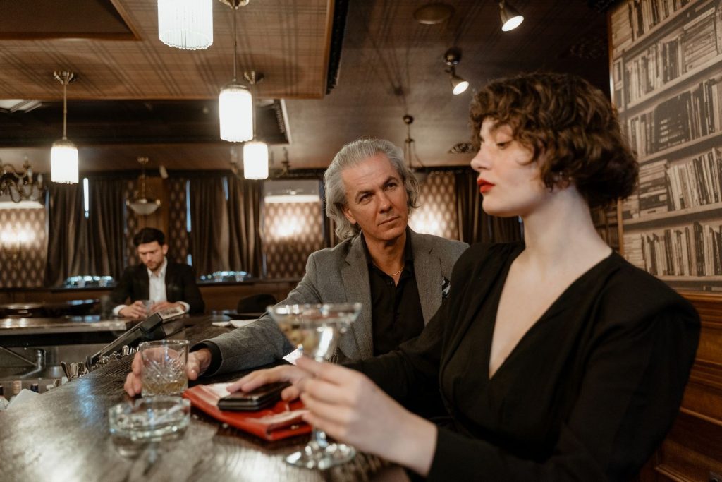Grey-haired man and his partner enjoying an evening out at a cocktail bar