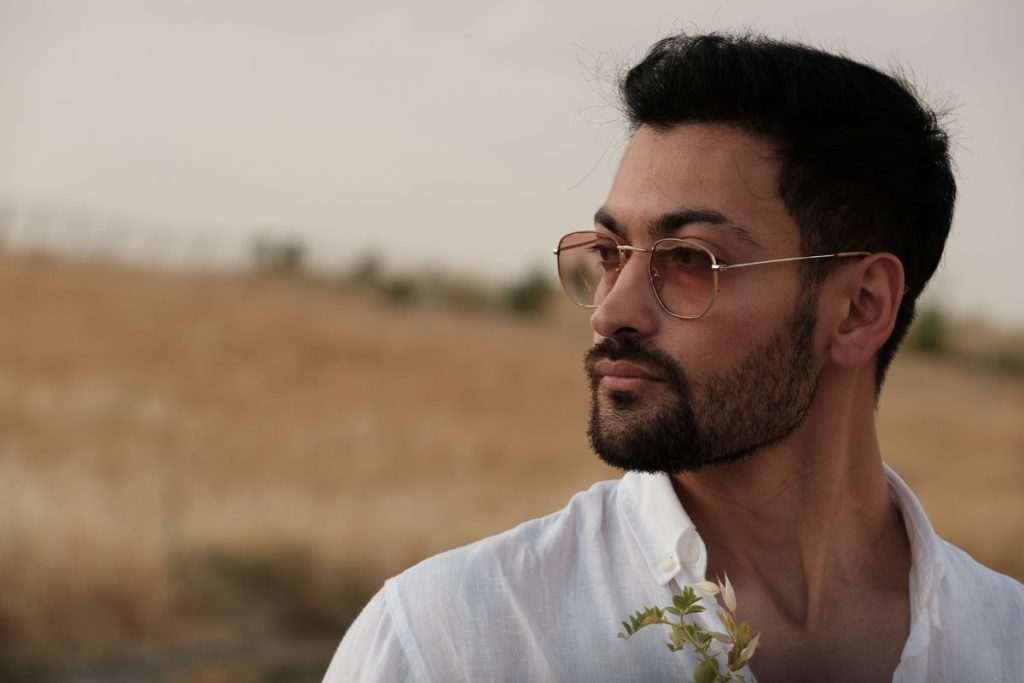 Man in glasses and a white linen shirt outdoors in golden evening light, illustrating regular check-ins and lab monitoring on TRT